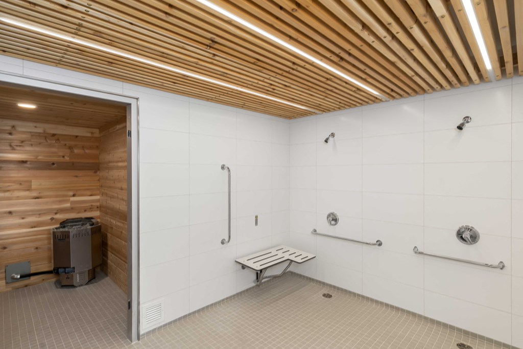 the interior of a sauna room with a wood ceiling and white walls
