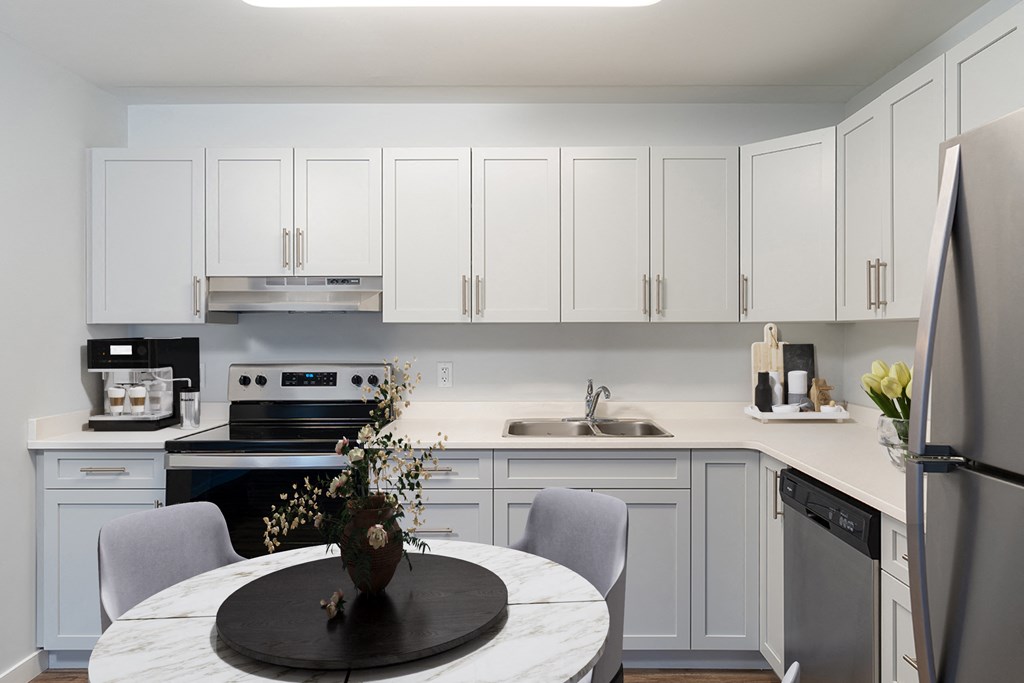 a kitchen with white cabinets and a round table