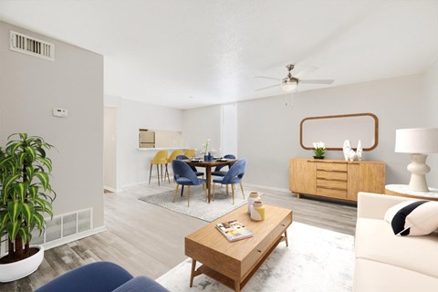 Living room with a blue couch, a wooden coffee table, and a dining table with chairs.