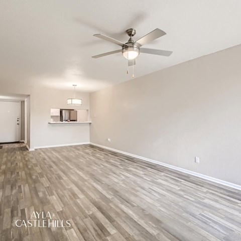 Spacious room with a ceiling fan and light fixture.