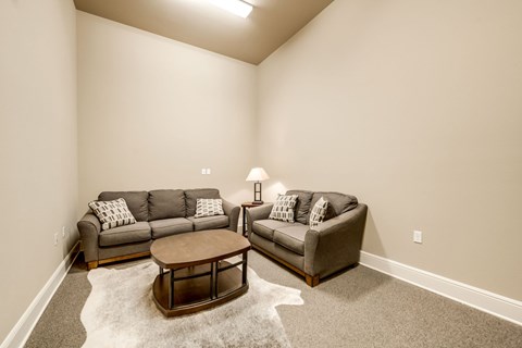A living room with a grey couch and a brown coffee table.