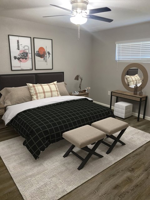 A bedroom with a bed, chair, and two framed pictures on the wall.