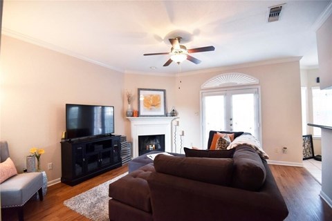 A living room with a brown couch and a fireplace.
