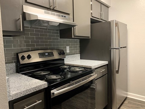 A kitchen with a black stove top oven and a black refrigerator.