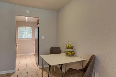 A dining room with a white table and chairs.