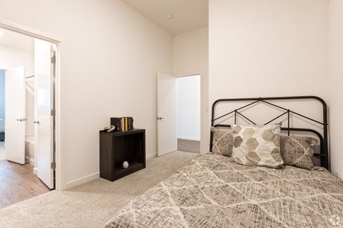 A bedroom with a bed, nightstand, and a rug.