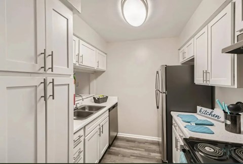 Kitchen with white cabinets and a black refrigerator.