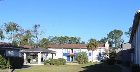 A building with a blue door is surrounded by greenery.