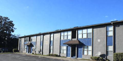 A grey building with blue doors and windows.
