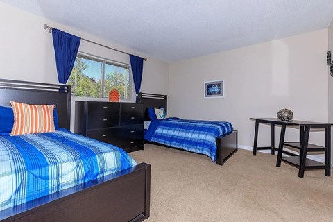 A bedroom with two beds and a dresser.