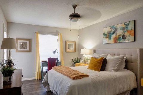 A bedroom with a large bed and a ceiling fan.