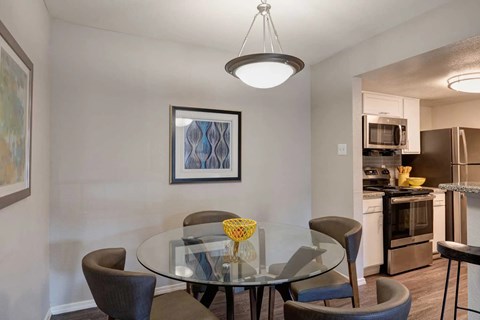 A modern dining room with a glass table and chairs.
