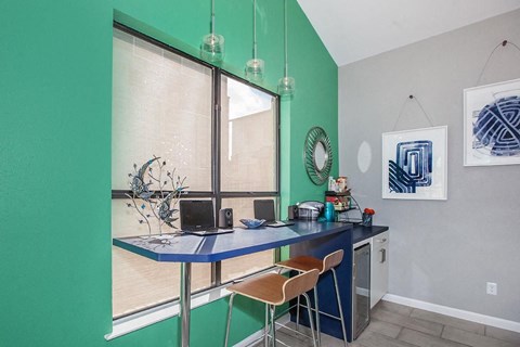 A kitchen with a table and chairs.