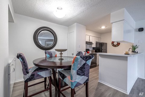 A dining room with a round table and chairs.