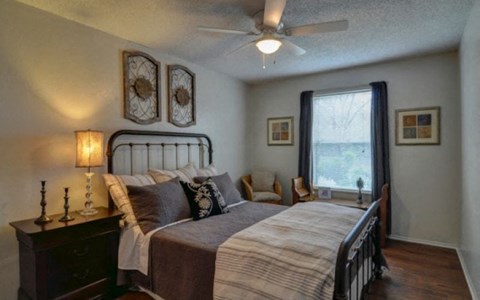 A bedroom with a large bed and a ceiling fan.