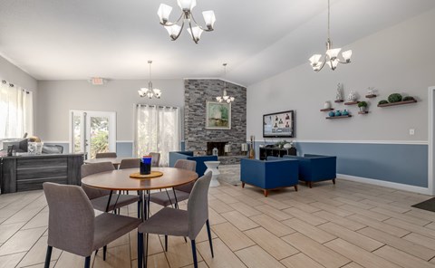 Dining room with a stone fireplace and a wooden table.