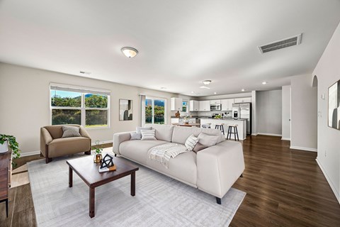 A living room with a white couch and a brown coffee table.