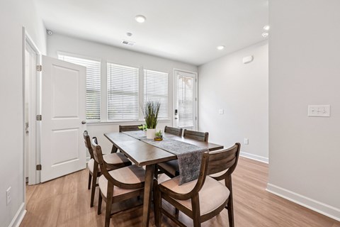 A dining room with a table and chairs.