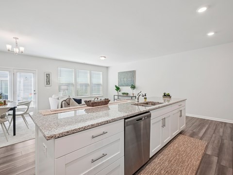 A kitchen with white cabinets and a granite countertop.