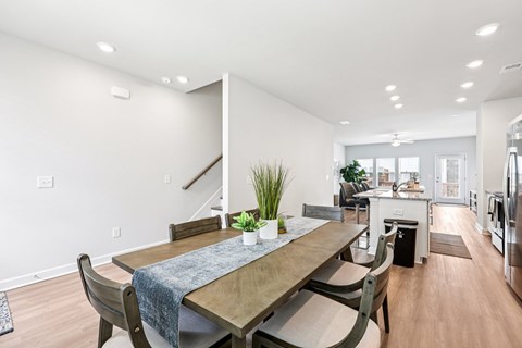 A modern dining room with a wooden table and chairs.