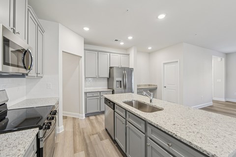 A modern kitchen with granite countertops and stainless steel appliances.