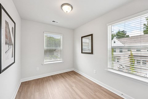 A room with a window and a picture on the wall.