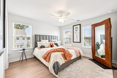 A bedroom with a large bed and a large mirror on the wall.