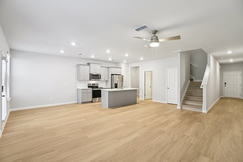 A spacious room with wooden flooring and a ceiling fan.