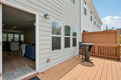 A small balcony with a table and chairs.