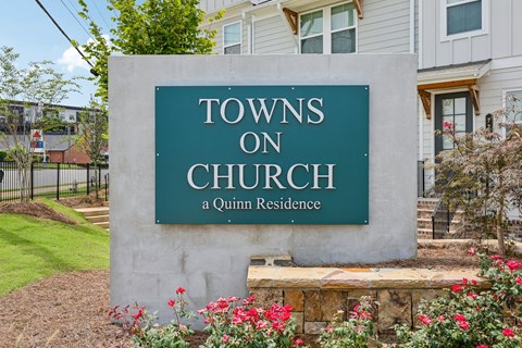 A sign that says Towns on Church stands in front of a building.