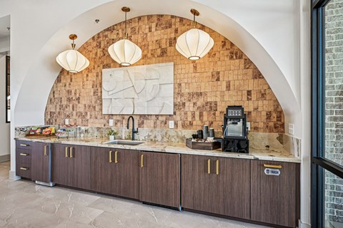 A kitchen with a brick wall and wooden cabinets.