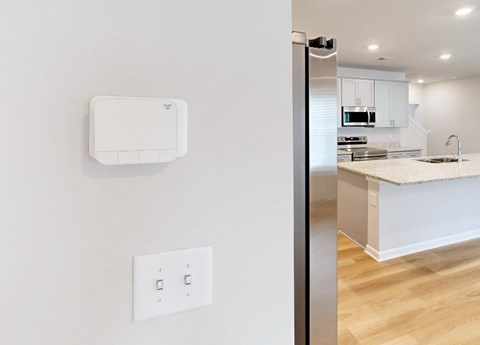 A white wall with a switch and a white box on it.