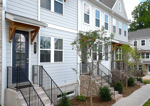 A house with a blue door and a black railing.