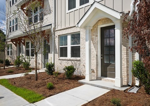A white house with a grey door and windows.