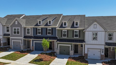 A row of houses with garages and driveways.