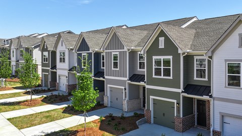 A row of houses with a tree in front of them.