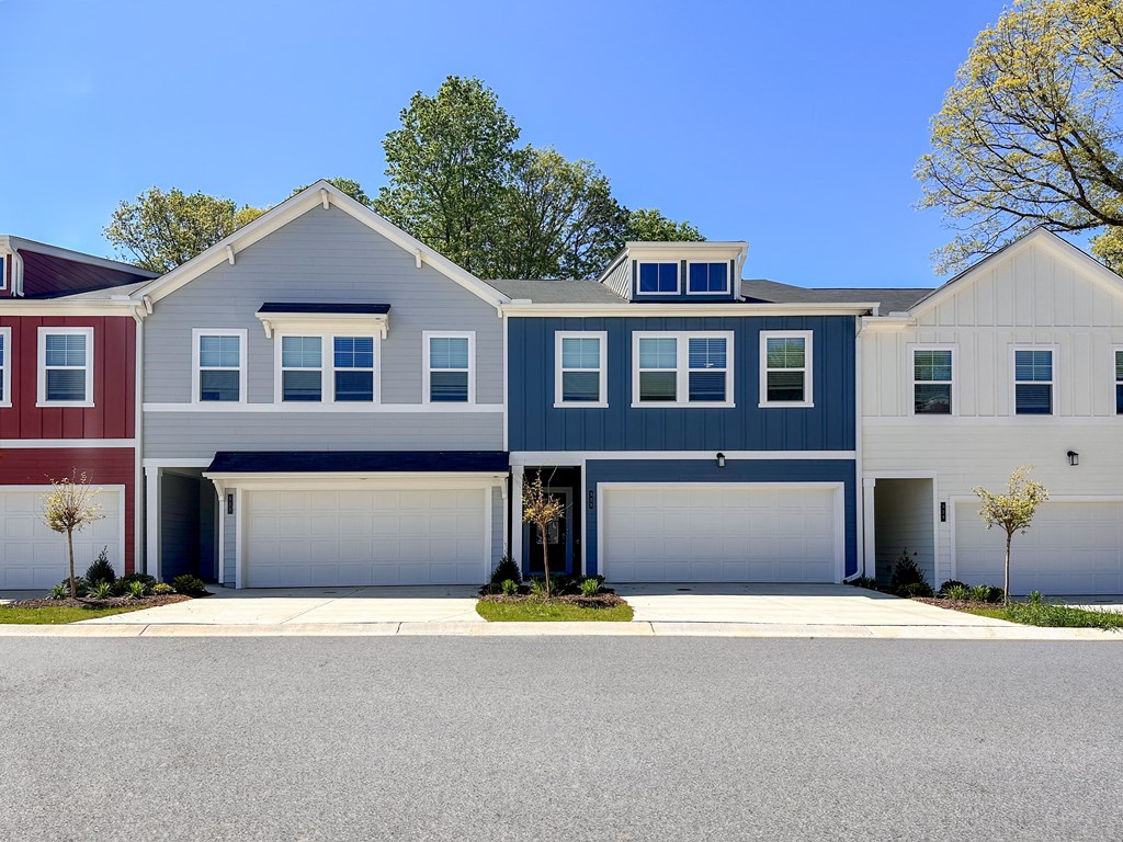 A row of houses with garages and driveways.