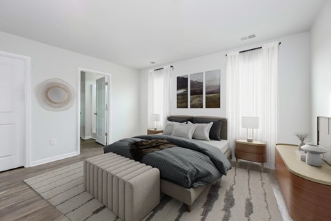 a bedroom with white walls and a bed with gray blankets and pillows