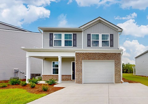 A two-story house with a garage door and a driveway.