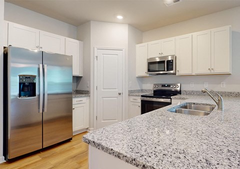 A kitchen with granite countertops and stainless steel appliances.