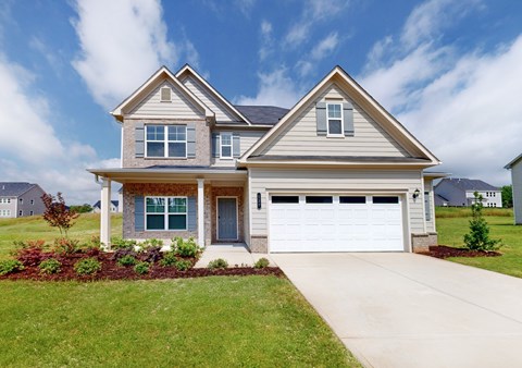 A two-story house with a garage and a driveway.