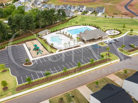 A large outdoor swimming pool with a slide and a small pool with a slide.