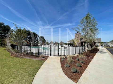a fence with a pool in front of a house