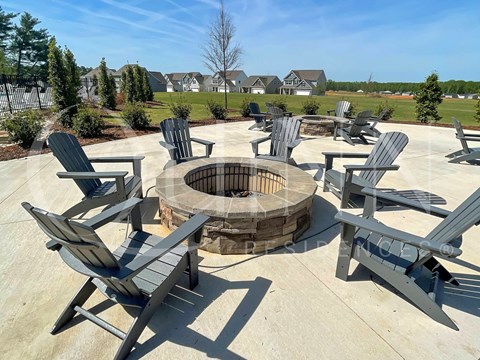 a fire pit with chairs around it on a patio