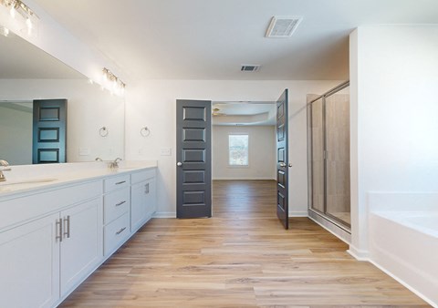 A bathroom with a wooden floor and white walls.