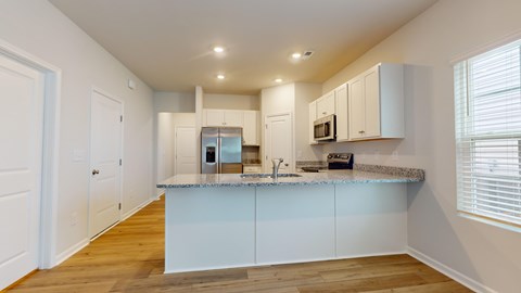 A kitchen with white cabinets and a granite countertop.