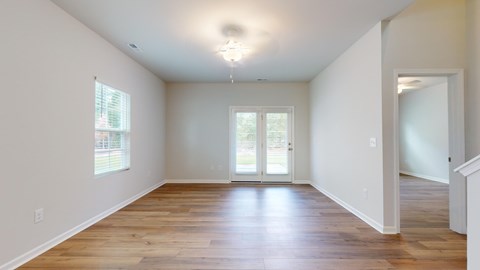A room with wooden floors and a chandelier hanging from the ceiling.