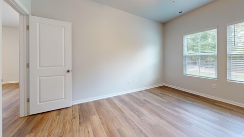 A room with a white door and a window with blinds.