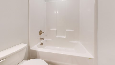 A white toilet and sink in a bathroom.