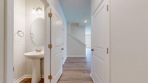 A white sink with a round mirror above it.